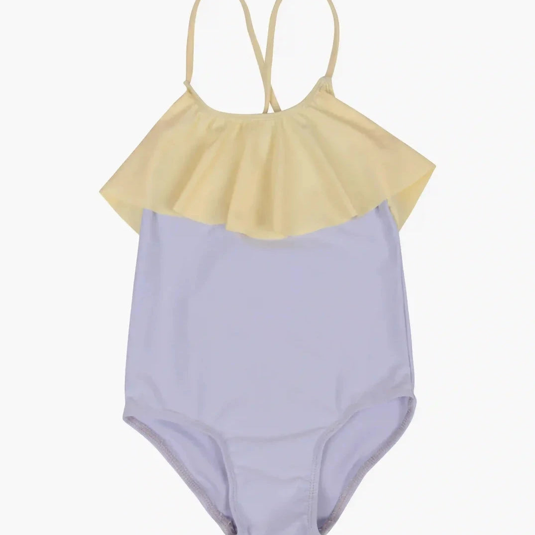 Beschreibung: Der Ava Mädchen Badeanzug von Main Design verfügt über dünne, verstellbare Träger. Der obere Teil ist hellgelb mit einem Rüschenbesatz, der sich über die Brust erstreckt, während der untere Teil helllila gehalten wird. Die Träger kreuzen sich hinten in einer schlichten „X“-Form.
