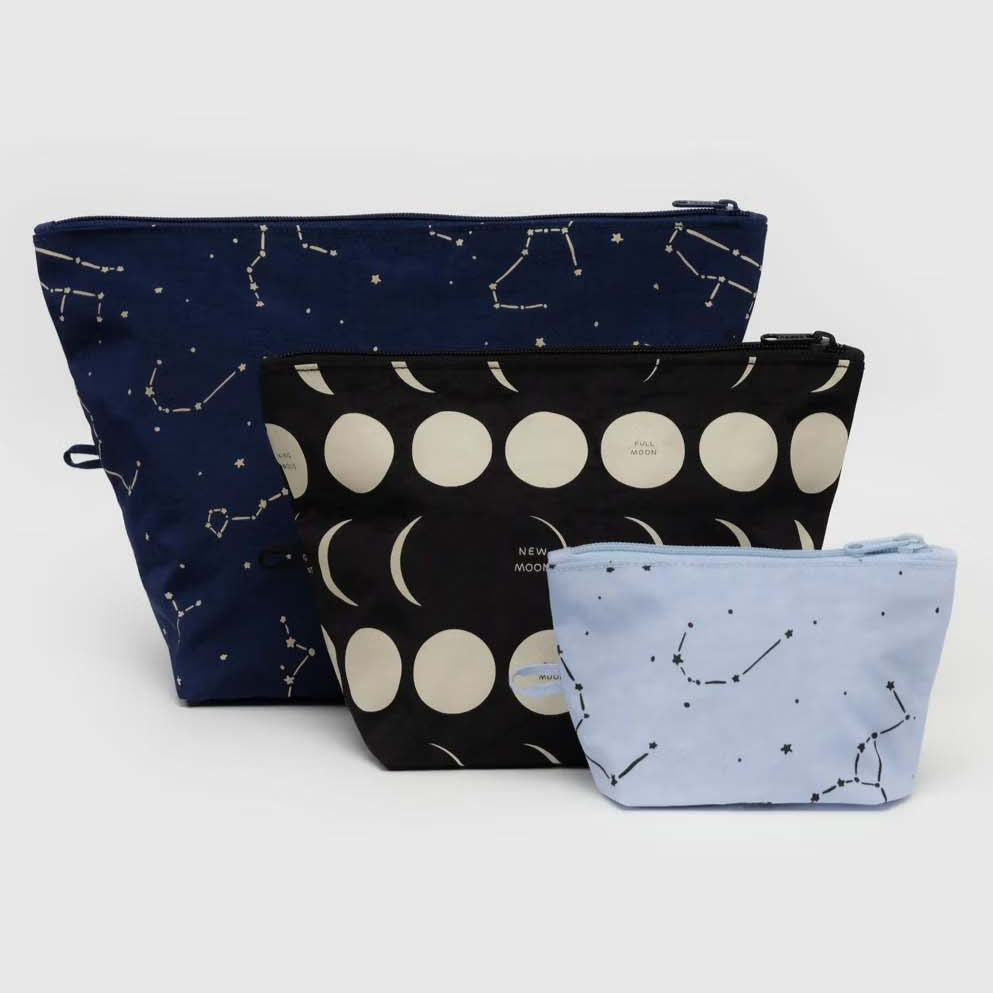 Das BAGGU Go Pouch Set von BAGGU besteht aus drei Reißverschlusstaschen mit Himmelsmotiven - dunkelblau mit Sternbildern, schwarz mit Mondphasen und hellblau mit Sternbildern - die jeweils aus recyceltem Nylon in verschiedenen Größen hergestellt werden.