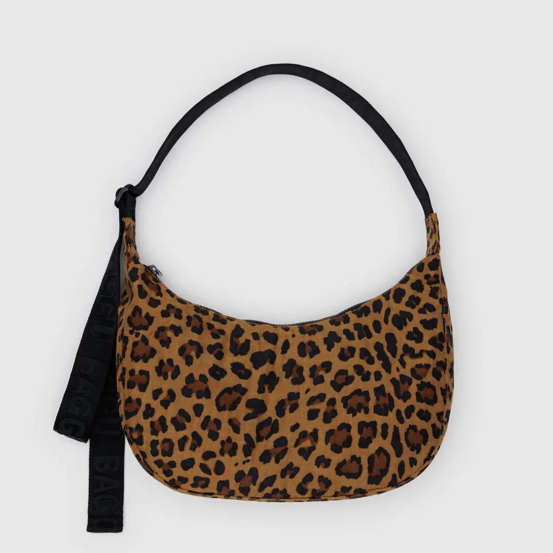 Die BAGGU Medium Nylon Crescent Bag von BAGGU hat eine kleine Größe, einen braunen und schwarzen Leopardenprint, einen schwarzen Riemen und einen Stoffanhänger - ideal als Umhängetasche für jeden Ausflug.