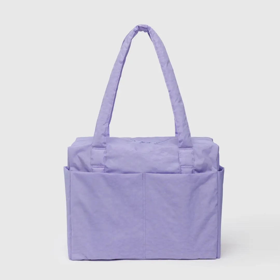 Die BAGGU Small Cloud Carry-On Tasche von BAGGU ist eine lavendelfarbene Tasche aus recyceltem Nylon mit zwei Schultergurten und Außentaschen. Sie hat die perfekte Größe für 16"-Laptops und ist ideal als Untersitz-Tasche. Ausgestellt auf einem schlichten hellen Hintergrund.
