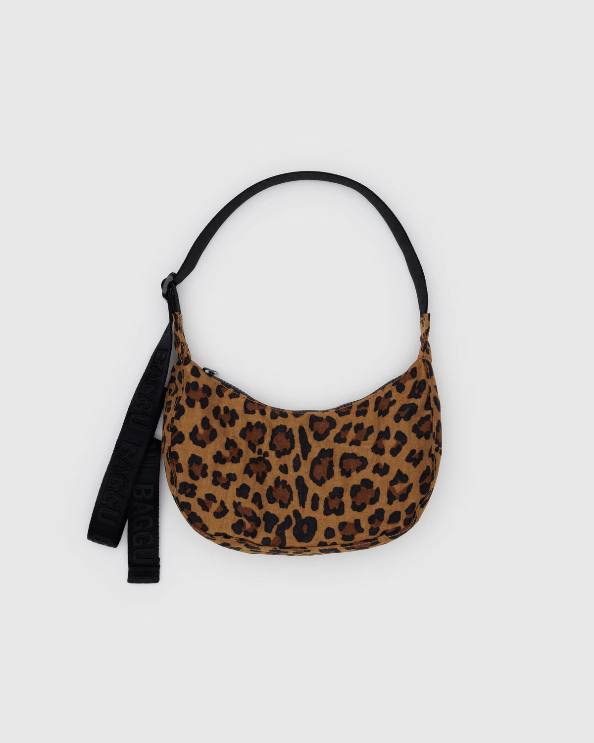 Die BAGGU Small Nylon Crescent Bag ist eine kompakte, halbmondförmige Umhängetasche von BAGGU aus recyceltem Nylon mit braunem und schwarzem Leopardenmuster, schwarzem Riemen und Schlüsselanhänger - ideal für umweltbewusste Fashionistas.