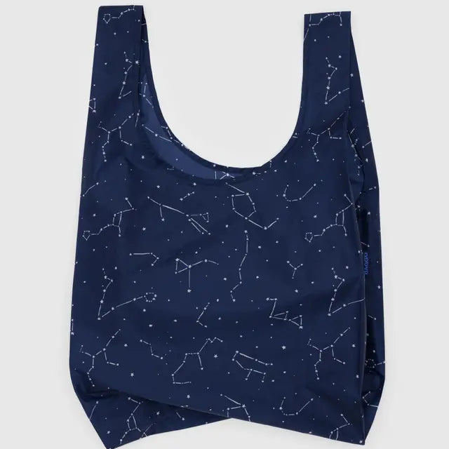 Die BAGGU Standard Tragetasche von BAGGU besteht aus recyceltem Ripstop-Nylon in Navyblau und zeigt ein weißes Sternbildmuster auf hellem Hintergrund.