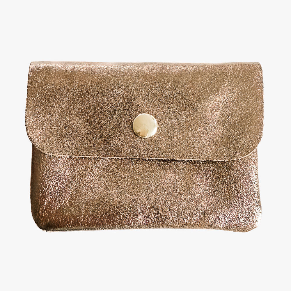 Ein kleines, goldfarbenes Babylone Leder Portemonnaie von Main Design mit Klappe und rundem, goldenem Knopf auf weißem Hintergrund.