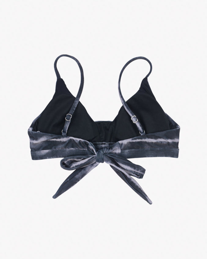 A black Adore Triangel Bikini Oberteil from Main Design with thin, verstellbare Schulterträger and a tie front detail. The tie front and lower band feature a dark grey tie-dye pattern made from umweltfreundlicher Stoff. The background is plain white.