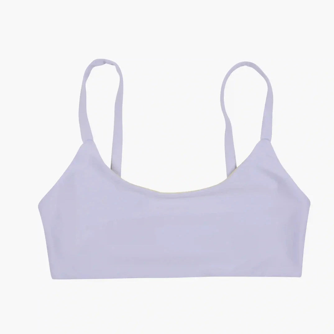 Ein weißes, wendbares Sassy-Bikini-Oberteil von Main Design, gefertigt aus nachhaltigen Materialien und mit dünnen Schulterträgern auf einem einfarbigen Hintergrund.