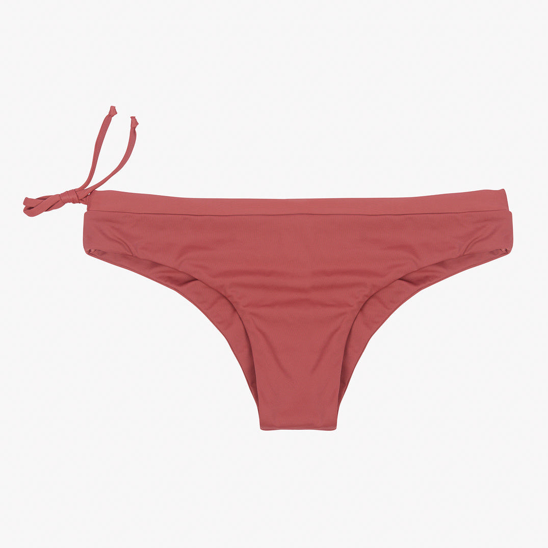 Wir präsentieren die Main Design Blush Surf Bikinihose, ein Paar rote Bikinihosen mit einem schlichten, klassischen Design. Dieser nachhaltige Bikini mit einem Kordelzug auf der linken Seite für eine verstellbare Passform ist aus umweltfreundlichem Stoff gefertigt und wirkt vor einem hellgrauen Hintergrund glatt und elegant.