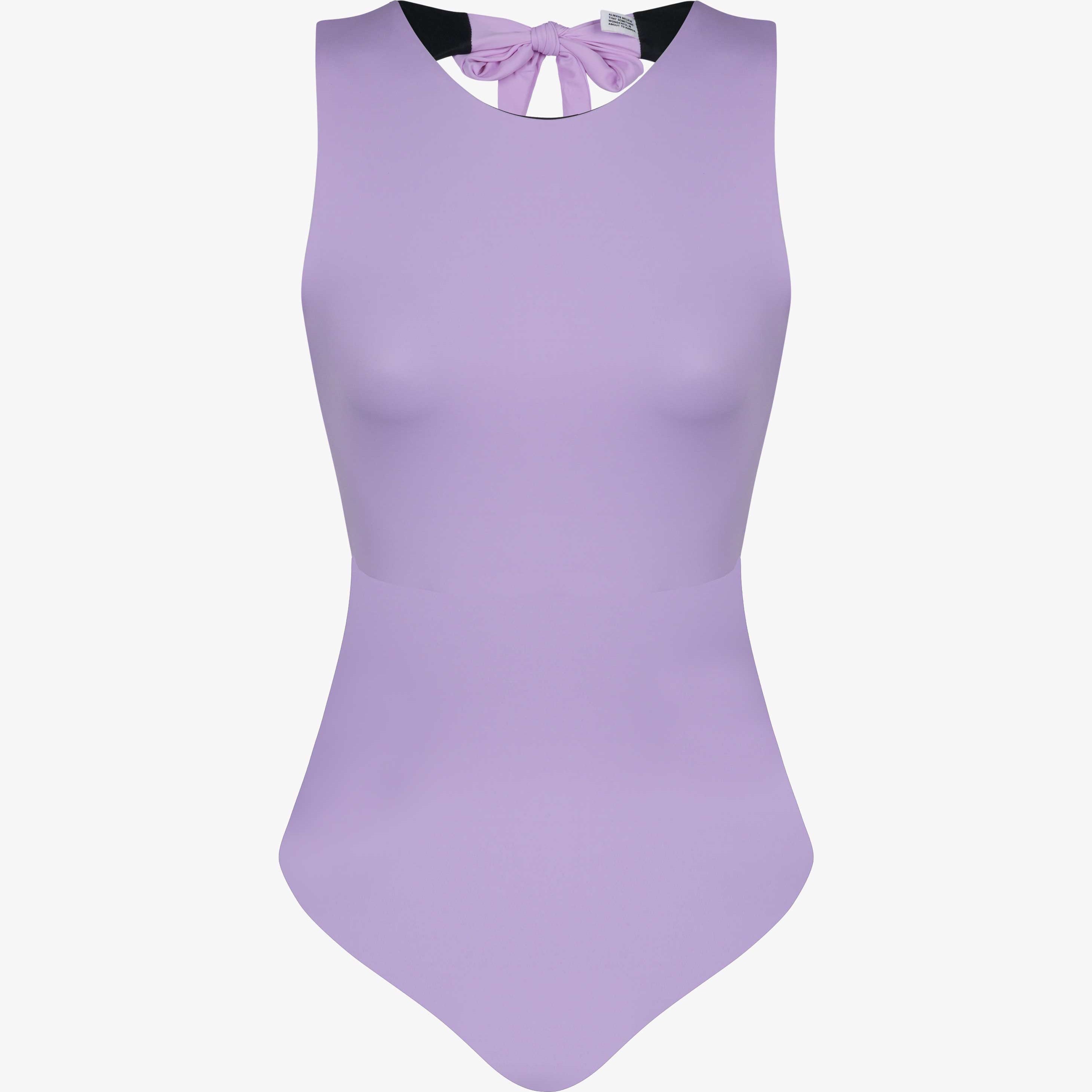 Der Divine Surf Badeanzug von Main Design ist ein ärmelloser, hellvioletter Badeanzug mit hohem Ausschnitt und einer Schleife am Rücken. Er ist aus recycelten Materialien gefertigt und wird auf einem schlichten weißen Hintergrund gezeigt.