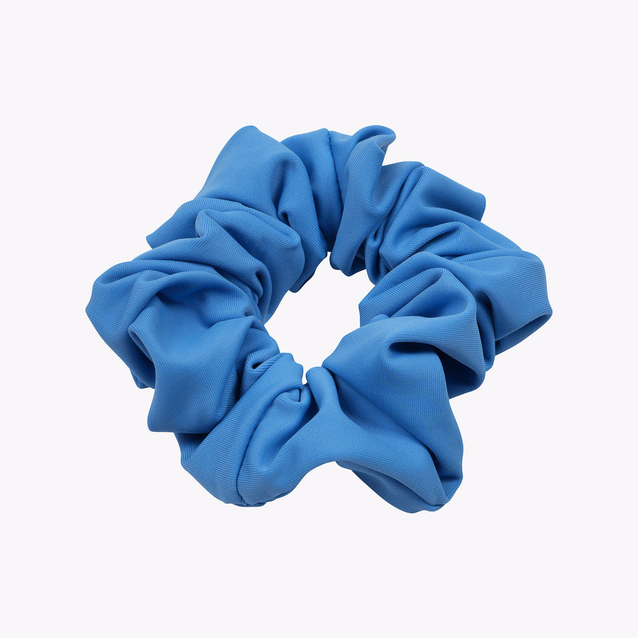 Das Haargummi einfarbig von Main Design ist ein blaues Stoff-Scrunchie mit geraffter, gekräuselter Textur, nachhaltig aus Stoffresten hergestellt und in kreisförmiger Form auf schlichtem weißem Hintergrund dargestellt.