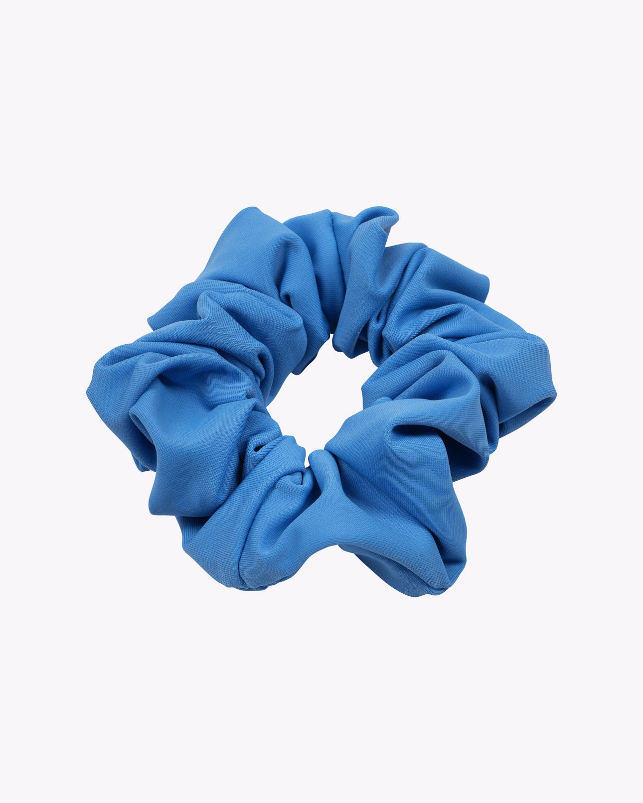 Das Haargummi einfarbig von Main Design ist ein blaues Stoff-Scrunchie mit geraffter, gekräuselter Textur, nachhaltig aus Stoffresten hergestellt und in kreisförmiger Form auf schlichtem weißem Hintergrund dargestellt.