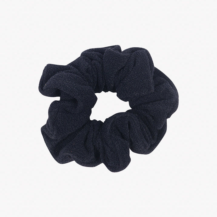 Ein Haargummi mini von Main Design aus recyceltem Stoff ist vor einem schlichten weißen Hintergrund abgebildet. Das Haargummi mini hat ein gerafftes Aussehen und ist so konzipiert, dass es das Haar an Ort und Stelle hält und gleichzeitig umweltfreundlich ist.