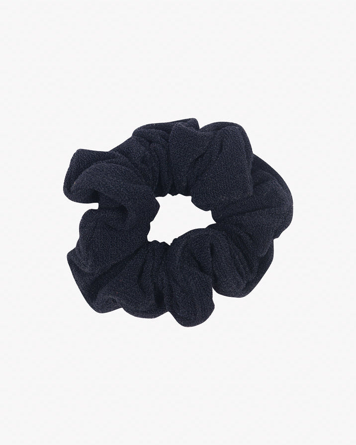 Ein Haargummi mini von Main Design aus recyceltem Stoff ist vor einem schlichten weißen Hintergrund abgebildet. Das Haargummi mini hat ein gerafftes Aussehen und ist so konzipiert, dass es das Haar an Ort und Stelle hält und gleichzeitig umweltfreundlich ist.