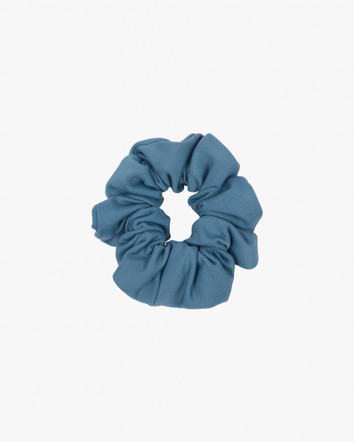 Auf einem schlichten weißen Hintergrund ist ein blaues Haargummi mini von Main Design aus recyceltem Stoff abgebildet. Die weiche, geraffte Optik dieses umweltfreundlichen Accessoires eignet sich gut zum Binden der Haare.