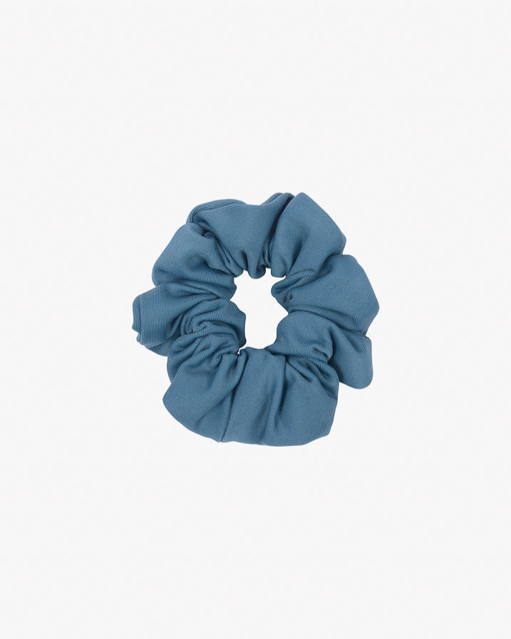 Auf einem schlichten weißen Hintergrund ist ein blaues Haargummi mini von Main Design aus recyceltem Stoff abgebildet. Die weiche, geraffte Optik dieses umweltfreundlichen Accessoires eignet sich gut zum Binden der Haare.