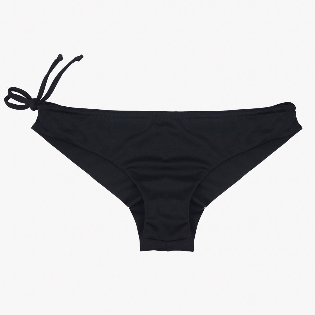 Schwarze Keira Surf Bikinihose für Damen von Main Design mit einer Schleife auf der linken Seite. Dieser nachhaltige Bikini besticht durch ein einfaches, nahtloses Design und einen glatten Stoff, der flach auf einem schlichten weißen Hintergrund liegt.