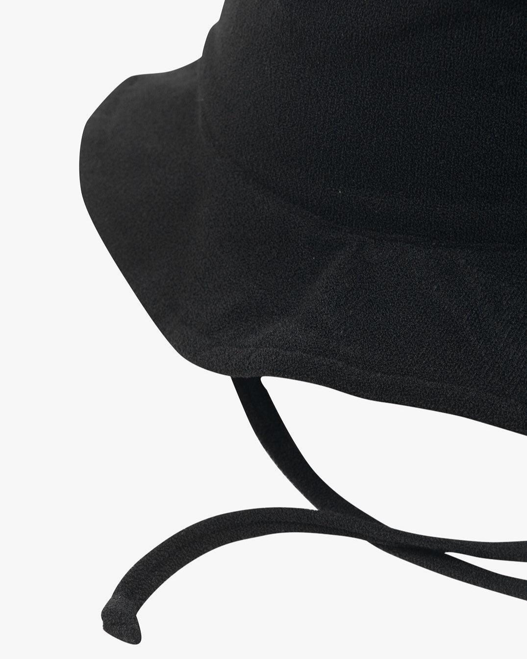 Eine Nahaufnahme eines schwarzen Kinder-Sonnenhuts mit breiter Krempe und zwei herabhängenden Kinnriemen. Der Hut aus umweltfreundlichem Stoff hat ein einfaches, schmuckloses Design und steht vor einem schlichten weißen Hintergrund.