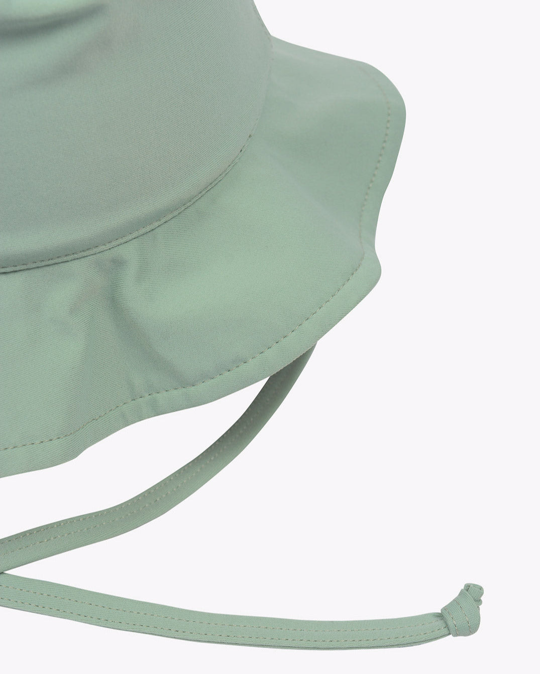 Eine Nahaufnahme eines hellgrünen Kinder-Sonnenhuts von Main Design mit genähter Krempe und verstellbarem Kinnriemen. Das Material, vermutlich umweltfreundlicher Stoff, wirkt glatt und langlebig. Mit einem LSF von 50+ ist er perfekt als Sonnenschutz geeignet. Der schlichte weiße Hintergrund hebt die Details und die Farbe des Huts hervor.