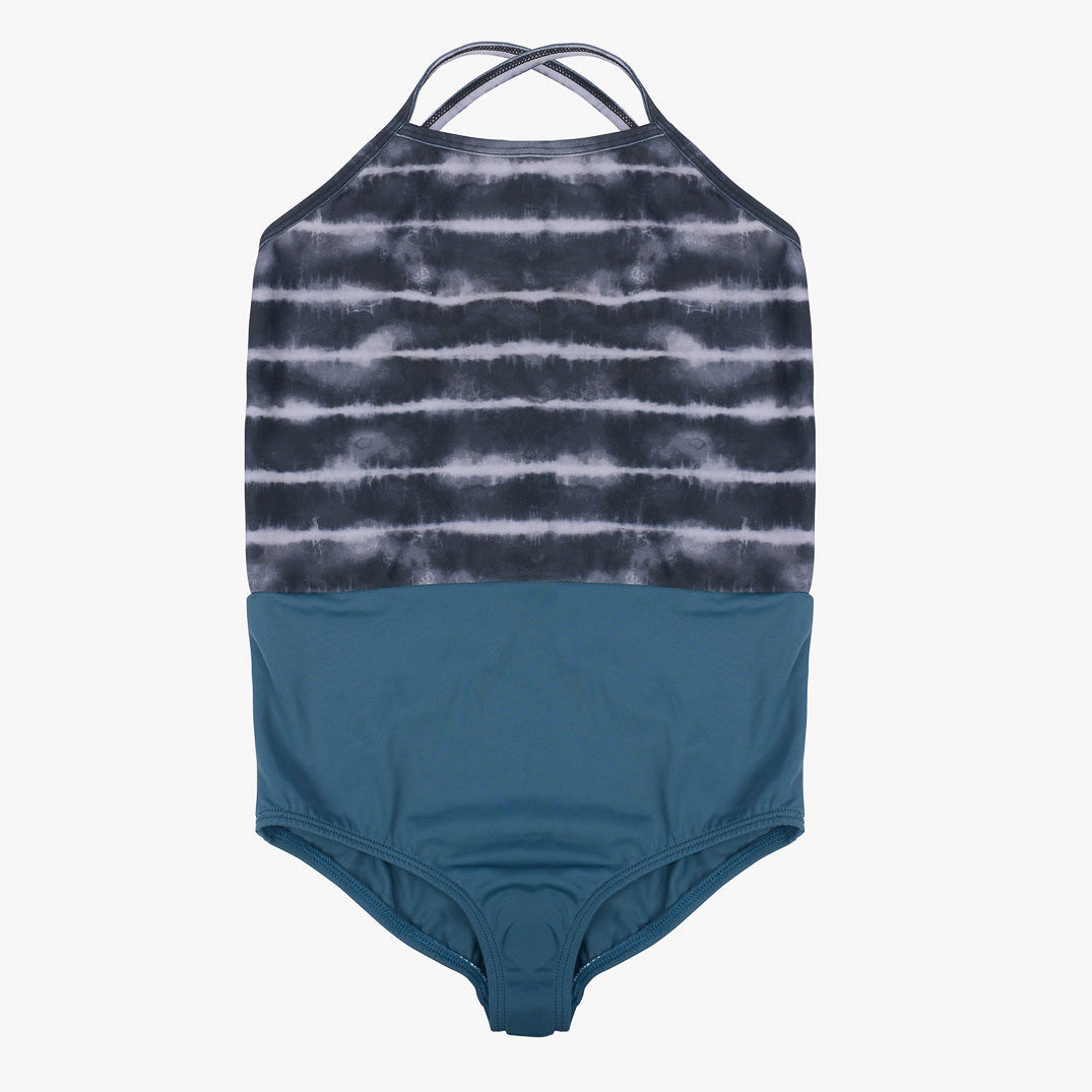 Ein einteiliger Badeanzug für Mädchen mit Neckholder-Ausschnitt und gekreuzten Trägern auf der Rückseite. Die obere Hälfte ist mit einem schwarz-weißen Batikmuster gestaltet, während die untere Hälfte einfarbig blaugrün ist. Dieser Main Design Lena Mädchen Badeanzug liegt flach auf einem schlichten weißen Hintergrund.