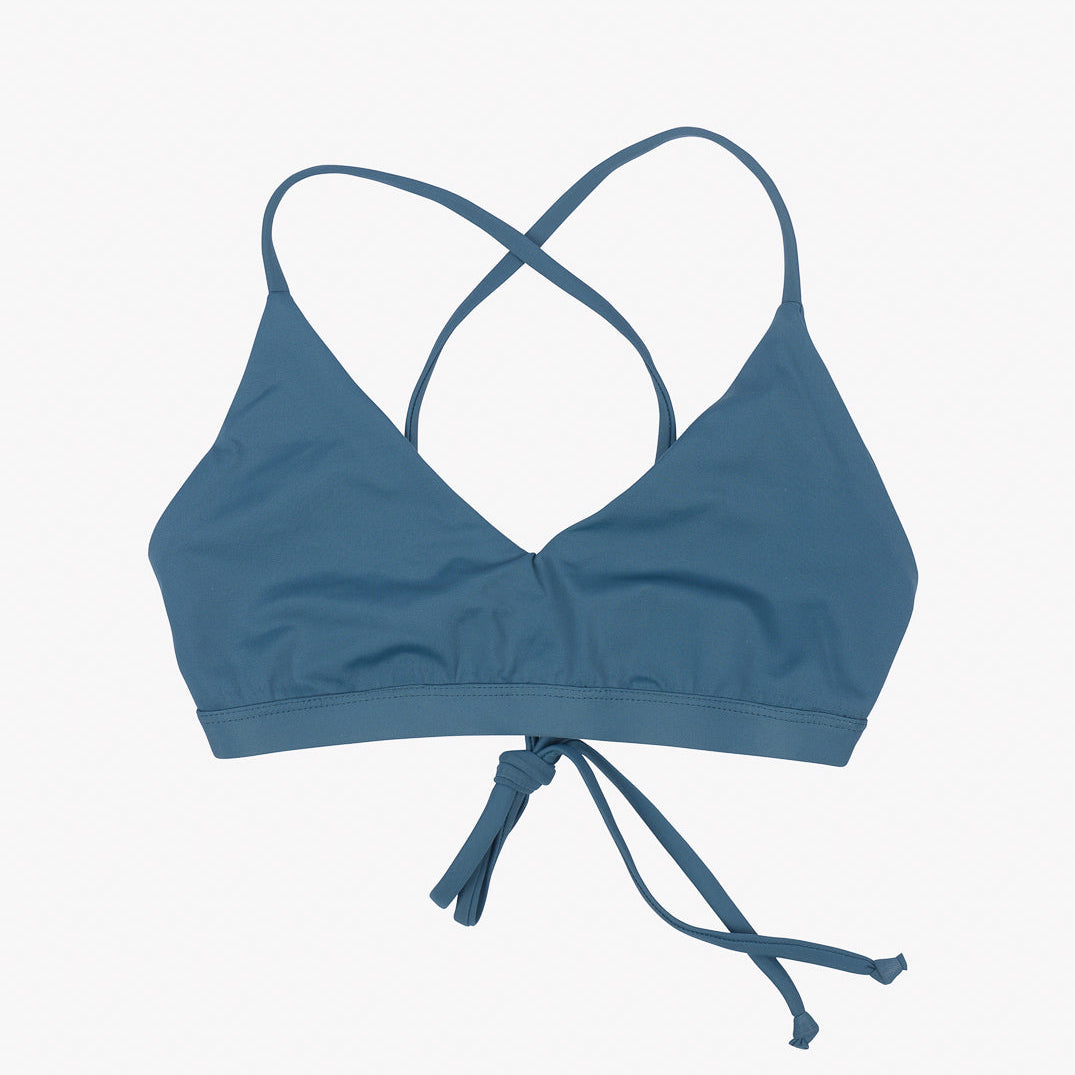 Ein Pasta-Bikini-Oberteil von Main Design mit dreieckigen Cups, überkreuzten Trägern auf der Rückseite und einem Bindeverschluss vorne. Das Design ist schlicht und elegant, hergestellt aus umweltfreundlichem Stoff, ideal für Badebekleidung. Perfekt als nachhaltiges Surf-Bikini-Oberteil vor einem schlichten weißen Hintergrund.