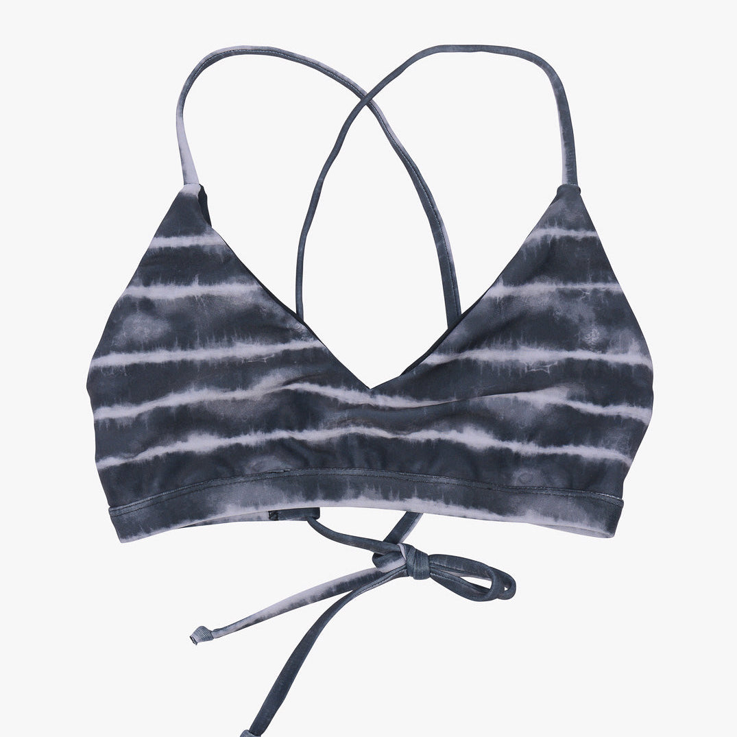 Ein Pasta-Bikini-Oberteil mit schwarz-weißem Muster. Das Bralette hat dünne, sich kreuzende Träger und ein Knotendetail auf der Rückseite. Es besteht aus umweltfreundlichem Stoff, ist weich und dehnbar und bietet eine bequeme Passform. Das Gesamtdesign ist lässig, stylisch und perfekt als Surf-Bikini-Oberteil von Main Design.
