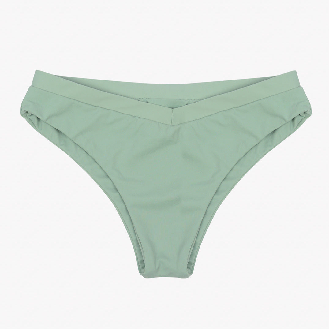 Ein Paar mintgrüne Ember Bikinihosen mit schlichtem und einfachem Design. Der aus recycelten Materialien gefertigte Bund weist ein dezentes V-förmiges Vorderdetail auf, das dem insgesamt schlichten und minimalistischen Erscheinungsbild einen Hauch von Eleganz verleiht. Der nahtlose Stoff wirkt glatt und bequem. Dies ist Teil der Kollektion von Main Design.