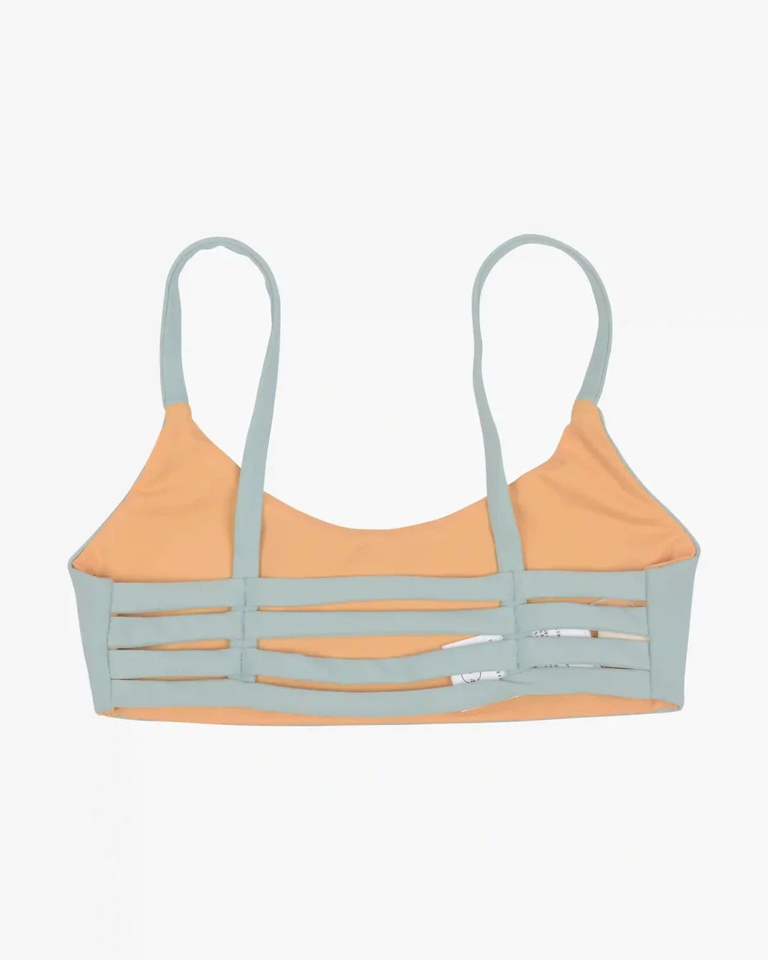 Wir präsentieren das Sassy Bikini Oberteil reversibel von Main Design, ein trendiges Bralette mit hellblauen Trägern und Kanten, gepaart mit einem pfirsichfarbenen Oberteil. Dieses aus nachhaltigen Materialien gefertigte Stück verfügt über moderne horizontale Ausschnitte auf der Vorderseite und wird stilvoll flach auf einen schlichten Hintergrund gelegt, um einen kantigen Look zu erzielen.