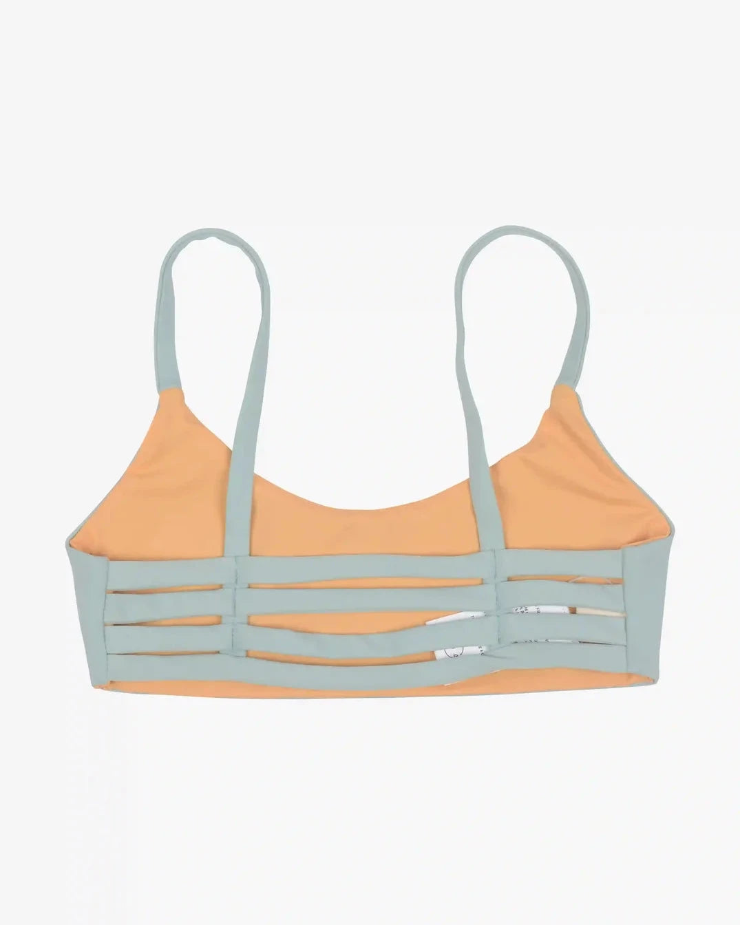 Wir präsentieren das Sassy Bikini Oberteil reversibel von Main Design, ein trendiges Bralette mit hellblauen Trägern und Kanten, gepaart mit einem pfirsichfarbenen Oberteil. Dieses aus nachhaltigen Materialien gefertigte Stück verfügt über moderne horizontale Ausschnitte auf der Vorderseite und wird stilvoll flach auf einen schlichten Hintergrund gelegt, um einen kantigen Look zu erzielen.