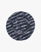 Ein runder, flachkrempiger Main Design Kinder-Sonnenhut mit einem Batikmuster in Schwarz-Weiß-Tönen. Der Hut hat einen lässigen, künstlerischen Look mit wellenförmigen, horizontalen Linien um die Krone und die Krempe. Er ist aus umweltfreundlichem Stoff gefertigt und bietet außerdem Sonnenschutz UPF 50+ für sicheren Spaß im Freien.