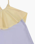 Ein Bild des Ava Mädchen-Badeanzugs von Main Design mit einem hellgelben Rüschenkragen und einem weichen lavendelfarbenen Oberteil. Dieser ärmellose Badeanzug hat ein zartes, feminines Design mit verstellbaren Trägern, die eine anpassbare Passform ermöglichen. Der schlichte weiße Hintergrund hebt die Farben und Details dieses bezaubernden Badeanzugs hervor.