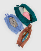 Das BAGGU 3D Zip Set von BAGGU besteht aus blauen, grünen und braunen Reißverschlusstaschen für Strickutensilien auf einer weißen Oberfläche - ideal als umweltfreundliche Taschen oder praktische Reisebegleiter.