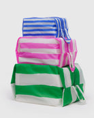 Das BAGGU 3D Zip Set von BAGGU besteht aus drei rechteckigen Reißverschlusstaschen mit blauen, pinken und grünen Streifen, die gestapelt als stilvolle Reise-Organizer präsentiert werden.
