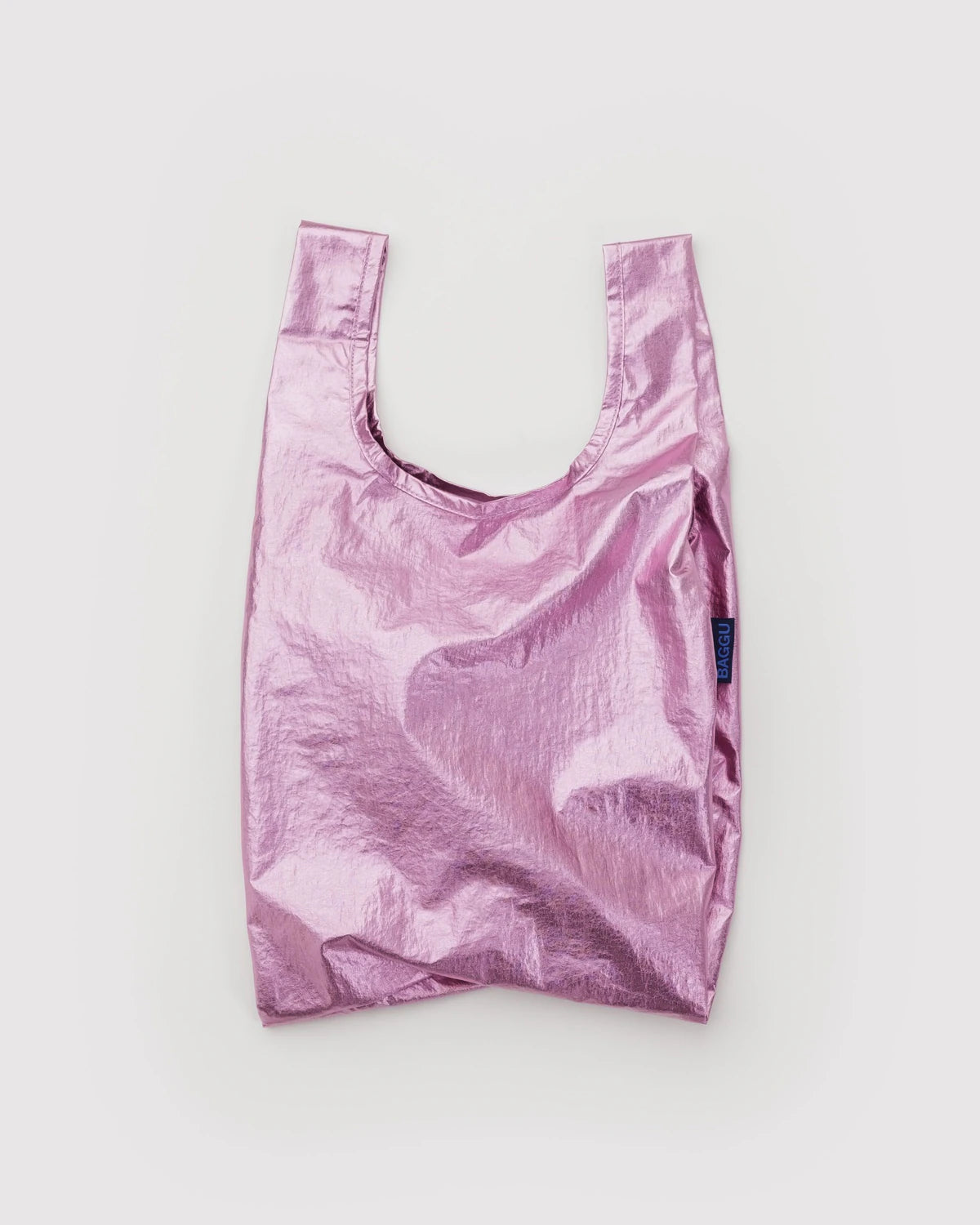 Eine glänzende, pinke BAGGU Baby Tragetasche aus recyceltem Nylon mit zwei Henkeln wird umweltfreundlich vor weißem Hintergrund präsentiert.