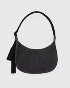 Die BAGGU Medium Denim Crescent Bag von BAGGU ist eine dunkelgraue, halbmondförmige Tasche mit einem breiten schwarzen Riemen und einem schwarzen Stoffanhänger auf der linken Seite. Sie ist aus recycelter Baumwolle gefertigt und auf einem einfarbigen hellgrauen Hintergrund abgebildet.