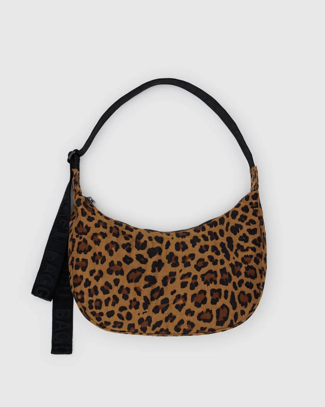 Die BAGGU Medium Nylon Crescent Bag von BAGGU hat eine kleine Größe, einen braunen und schwarzen Leopardenprint, einen schwarzen Riemen und einen Stoffanhänger - ideal als Umhängetasche für jeden Ausflug.