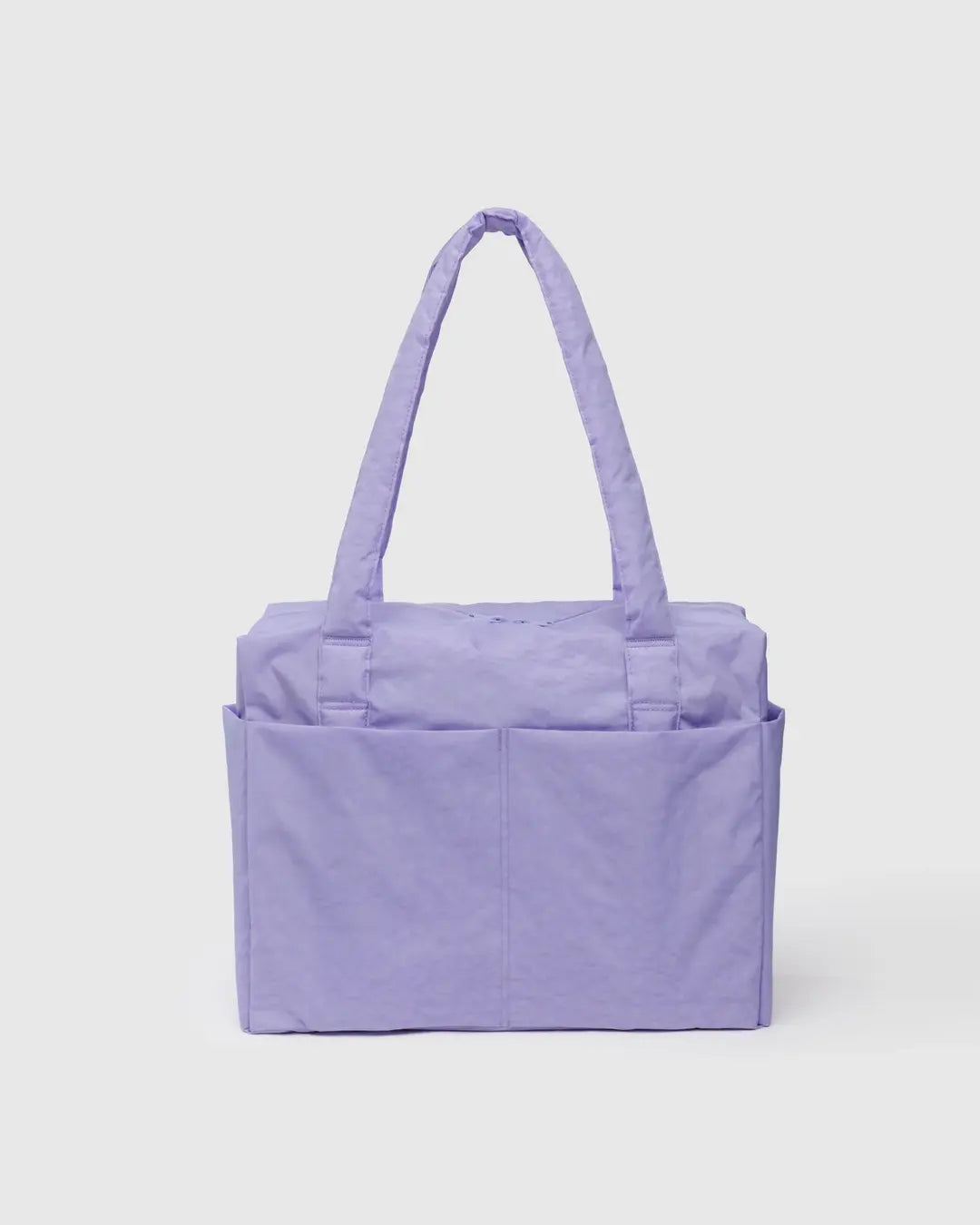 Die BAGGU Small Cloud Carry-On Tasche von BAGGU ist eine lavendelfarbene Tasche aus recyceltem Nylon mit zwei Schultergurten und Außentaschen. Sie hat die perfekte Größe für 16"-Laptops und ist ideal als Untersitz-Tasche. Ausgestellt auf einem schlichten hellen Hintergrund.