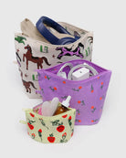 Das Main Design BAGGU Go Pouch Set besteht aus drei Beuteln aus recyceltem Nylon: groß (Pferde, Kopfhörer), mittelgroß (lila Blumen, Elektronik) und klein (Erdbeeren für Kosmetika und eine Tropfflasche).