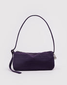 Die BAGGU Nylon Loaf Bag von BAGGU hat eine geschwungene Form, einen einzelnen Riemen und einen Reißverschluss mit einem kleinen, runden, silbernen Anhänger. Sie ist in lila auf einem schlichten, weißen Hintergrund abgebildet - ideal für eine Umhängetasche Damen.