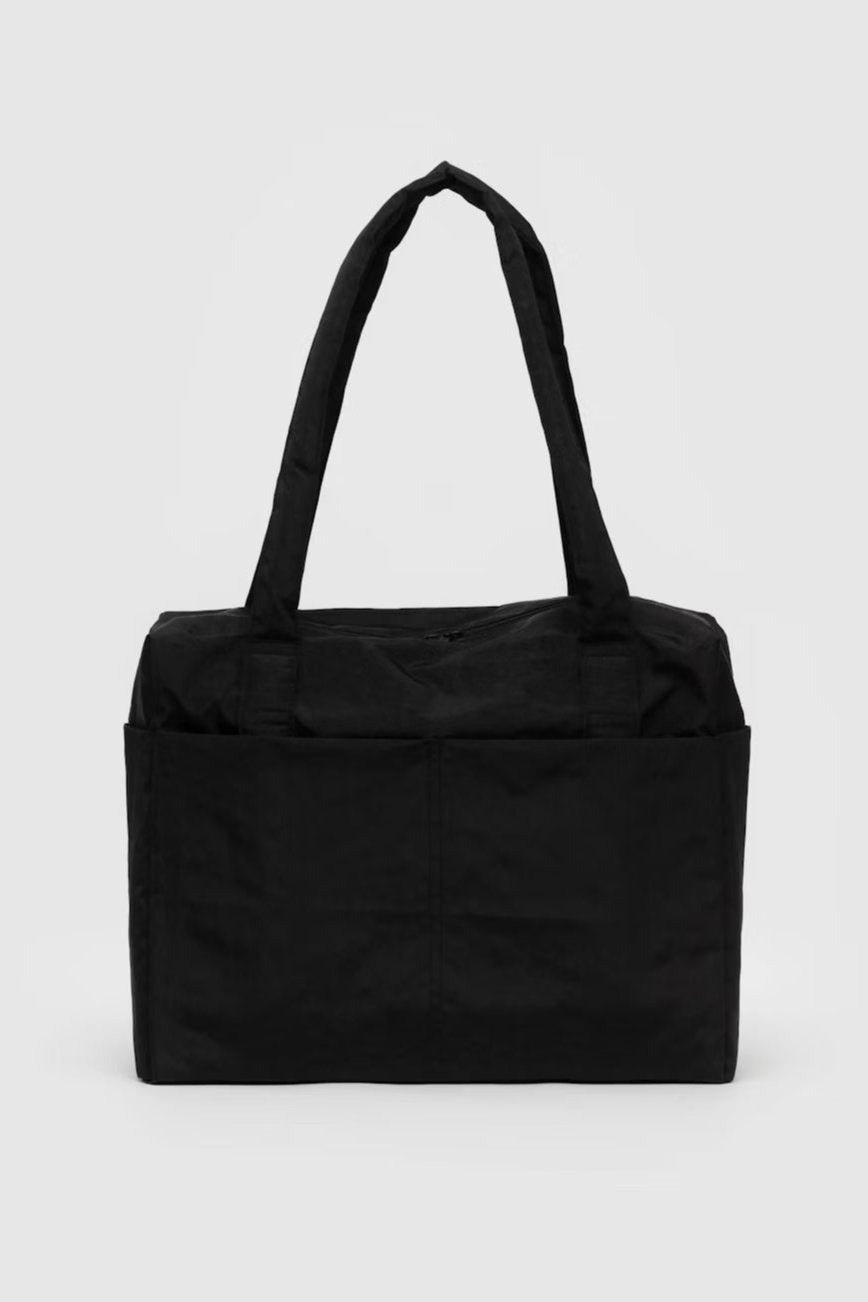 Eine kleine, schwarze Tragetasche mit minimalistischem Design auf schlichtem weißen Hintergrund. Die BAGGU Small Cloud Carry-On Tasche von Main Design verfügt über zwei lange Griffe und ein großes Hauptfach und eignet sich daher ideal als Laptoptasche oder Reisetasche.