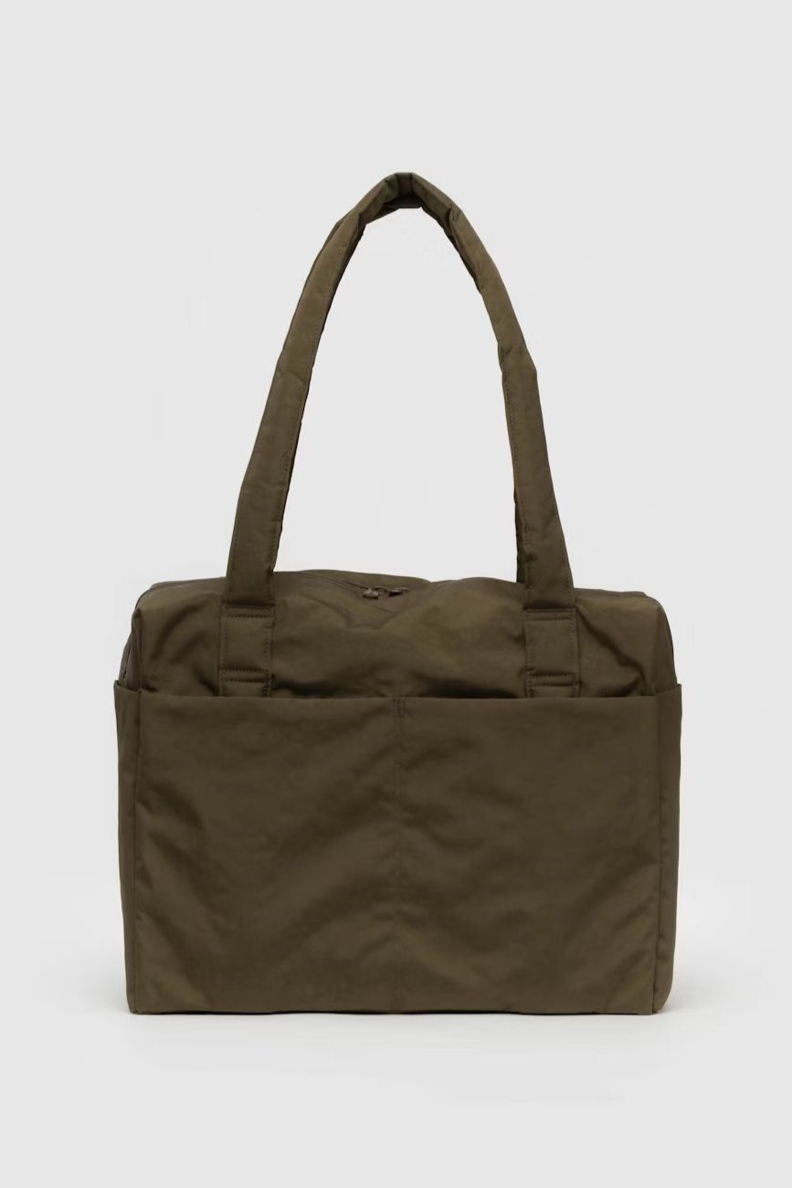 Eine grüne, rechteckige BAGGU Small Cloud Carry-On Tasche von Main Design mit zwei langen Griffen und einer Reißverschlusstasche auf der Vorderseite. Die Tasche hat ein schlankes, minimalistisches Design und scheint aus strapazierfähigem Stoff gefertigt zu sein, was sie perfekt als Reisetasche für Ihre täglichen Bedürfnisse macht.