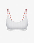 Das Sassy Bikini Oberteil reversibel von Main Design ist ein weißes Bralette mit rot-weiß gestreiften Schulterträgern aus chlorresistenter Stoff auf schlichtem Untergrund.