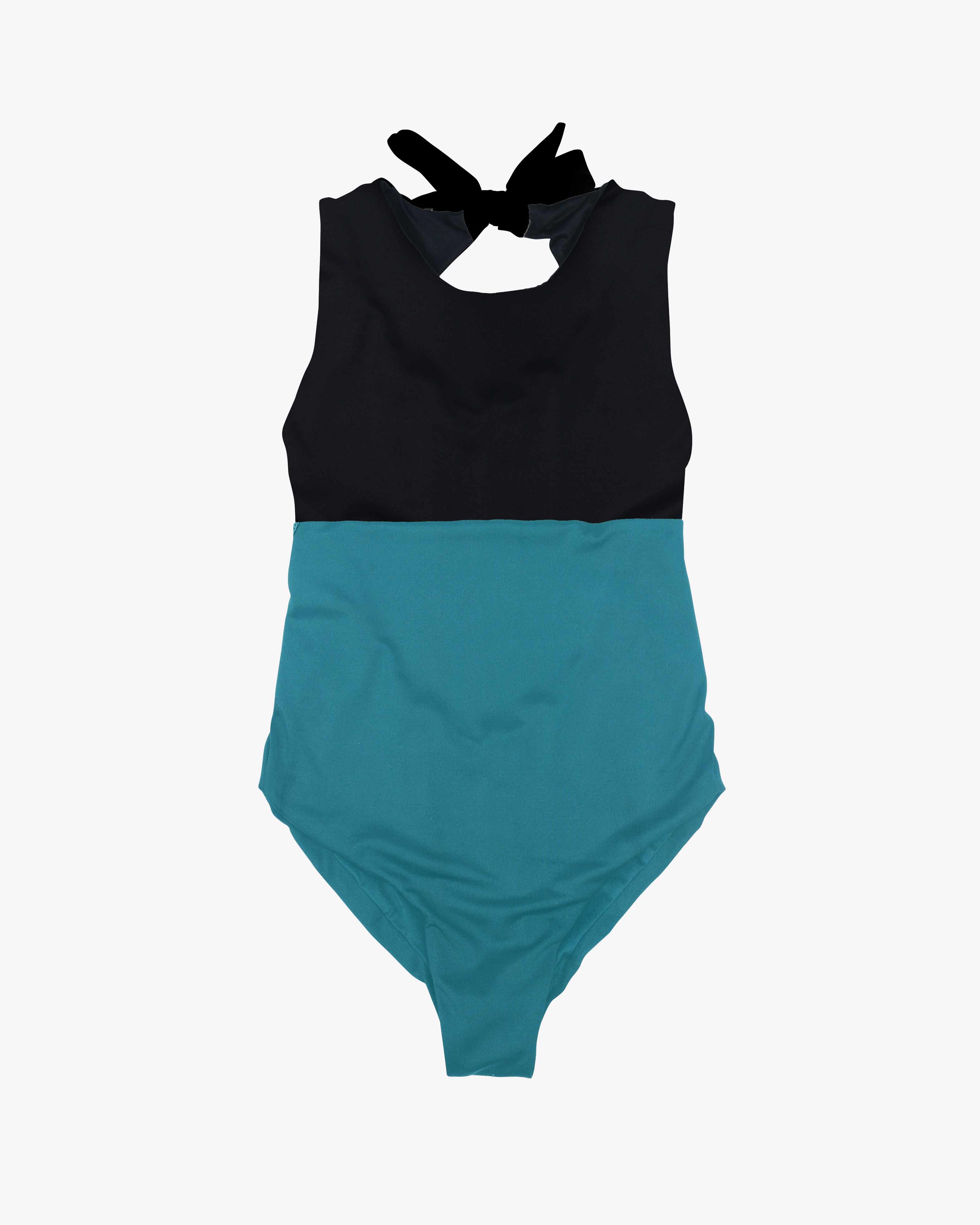 Der Divine Surf Badeanzug von Main Design ist ein ärmelloser Surfanzug mit einem auffälligen zweifarbigen Design: einem schwarzen Oberteil und einem türkisfarbenen Unterteil. Er hat einen hohen Ausschnitt, einen schwarzen Bindeverschluss am Rücken und ist aus umweltfreundlichem Stoff für umweltbewusste Schwimmer gefertigt.