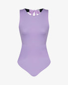 Der Divine Surf Badeanzug von Main Design ist ein ärmelloser, hellvioletter Badeanzug mit hohem Ausschnitt und einer Schleife am Rücken. Er ist aus recycelten Materialien gefertigt und wird auf einem schlichten weißen Hintergrund gezeigt.
