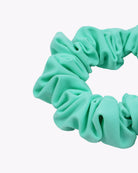 Eine Nahaufnahme des hellgrünen Haargummis einfarbig von Main Design, nachhaltig aus Stoffresten hergestellt und kreisförmig auf weißem Hintergrund angeordnet.