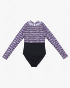 Ein langärmliger Ivy Surf Suit von Main Design mit einem lila-weißen Batikmuster auf der oberen Hälfte und einer schwarzen unteren Hälfte. Der Ivy Surf Suit aus recycelten Materialien hat einen runden Ausschnitt und ein Schlüsselloch-Detail auf der Rückseite mit einer kleinen Schleife oben. Dieses moderne und stilvolle Design bietet LSF 50+-Schutz.