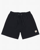 Ein Paar schwarze Main Design Lean Boardshorts für Jungen mit elastischem Bund und schwarzem Kordelzug. Die Shorts haben zwei Seitentaschen, 4-Wege-Stretch-Material, Sonnenschutzfaktor 50+ und einen kleinen rechteckigen beigen Patch mit einem Logo auf der unteren linken Seite.