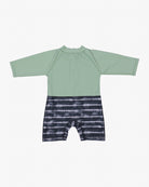Ein langärmliger, einteiliger Malia Baby-Badeanzug von Main Design für Kinder. Die obere Hälfte ist in Salbeigrün gehalten und hat Raglanärmel, während die untere Hälfte ein schwarz-weißes Batikmuster aufweist, das an horizontale Streifen erinnert. Ausgestattet mit Sonnenschutzfaktor 50+ für maximalen Schutz.