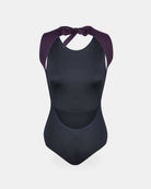 Der Divine Surf Badeanzug von Main Design ist ein stylischer schwarzer Badeanzug mit ärmellosem Schnitt und breiten, dunkelvioletten Trägern zum Binden. Mit seinem hohen Ausschnitt hat er einen modernen Look und ist aus recycelten Materialien hergestellt.