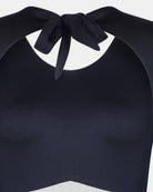 Nahaufnahme des Eclipse Surf Suit von Main Design - ein schwarzer, ärmelloser Anzug aus nachhaltigem Material mit Rundhalsausschnitt, großer Schleife am Rücken und weichem, dehnbarem Stoff.