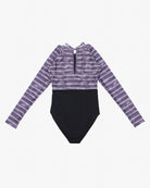 Ein Main Design Ivy Surf Suit aus recycelten Materialien, mit einem lila-weißen Batikmuster auf der oberen Hälfte und einfarbigem Schwarz auf der unteren Hälfte. Er verfügt über einen Reißverschluss vorne, eine kleine Schlüssellochöffnung mit Schleife am hinteren Ausschnitt und LSF 50+ für hervorragenden Sonnenschutz.