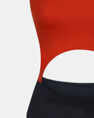 Nahaufnahme einer Person, die den Main Design Nova Badeanzug in Rot mit einem großen, geschwungenen Taillenausschnitt und einem hoch taillierten schwarzen Po trägt. Dieses nachhaltige Badeanzug-Foto konzentriert sich auf den Torso, Gesicht und Beine sind nicht zu sehen.
