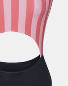 Eine Nahaufnahme des Main Design Nova Badeanzugs zeigt sein rosa und rot vertikal gestreiftes Oberteil mit einem seitlichen Ausschnitt, gepaart mit einem einfarbigen schwarzen Unterteil.